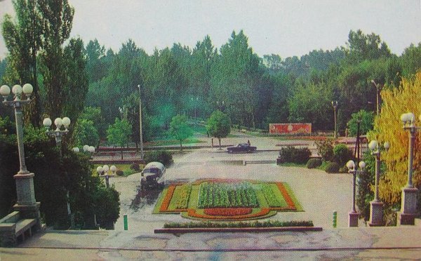 Водовоз поливає клумбу біля входу в парк