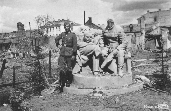 Німецький солдат фотографується біля розбитого пам'ятника Леніну і Сталіну