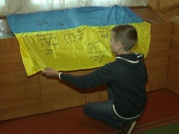 Волинський воїн подарував дітям прапор з підписами бойових побратимів