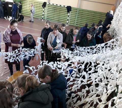 Школярі та вчителі волинської школи сплели величезну маскувальну сітку для воїнів