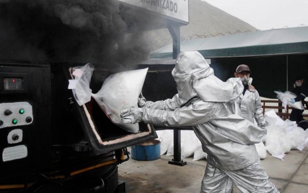 Перуанські поліцейські спалюють пакети з кокаїном, вилучені минулого тижня. В ході спецоперації в місті Трухільо на півночі Перу поліція вилучила у наркоторговців 7,6 тонни кокаїну. Це стало найбільшою партією за всю історію країни. (© Reuters)