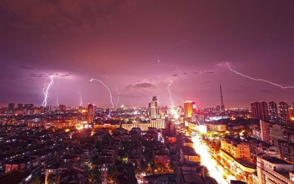 Блискавка пронизує небо над висотними будівлями під час грози в Куньшані, провінція Цзянсу, Китай. (© Reuters / Stringer)
