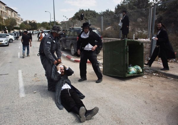 Ізраїльський поліцейський тягне ультра-православного чоловіка під час зіткнень в місті Бейт-Шемеш, неподалік від Єрусалиму, 12 серпня 2013. NIR ELIAS, Ізраїль