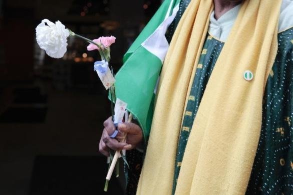 Жінка тримає гвоздику, беручи  участь у молитові за викрадених нігерійських школярок за межами Генерального консульства Нігерії в Манхеттені, Нью-Йорк 10 травня 2014. Боко Харам викрав більше 250 дівчата з середньої школи в Chibok в віддаленому північному