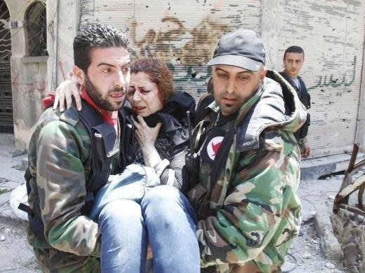 Чоловіки несуть поранену жінку після випадкового вибуху, викликаного залишками боєприпасів на Бустан аль-Диван, в старому Хомс Місто, 10 травня 