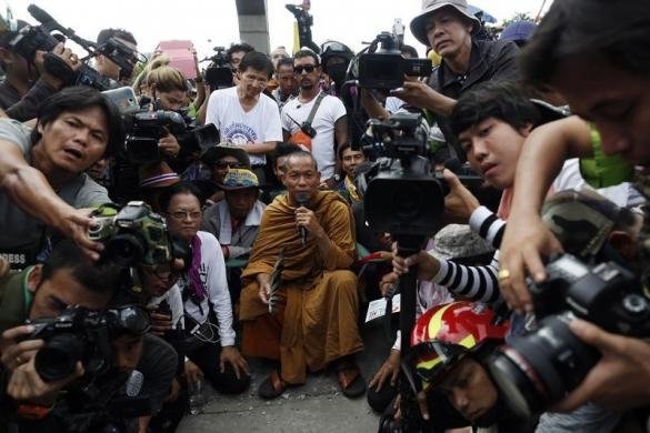Тайський буддійський чернець і протест лідера Луанг Пу Будди Іссара (C) оточений своїми прихильниками і журналістами