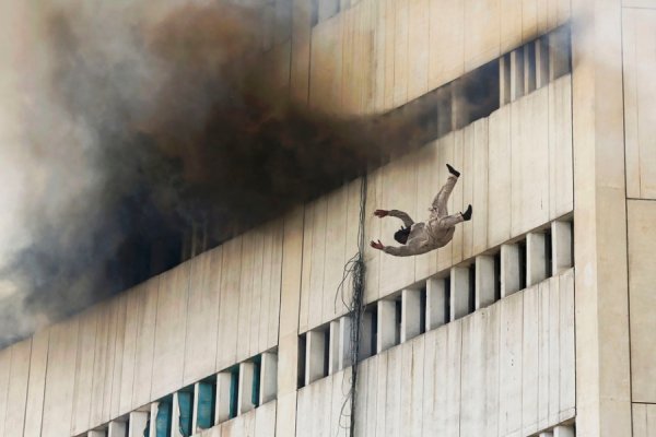 Чоловік падає з верхнього поверху палаючої будівлі в центрі Лахора, 9 травня 2013. DAMIR SAGOLJ, Пакистан