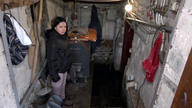 Мешканка села Любитів Наталія Солодовник показує підвал будинку, де досі стоїть вода. 