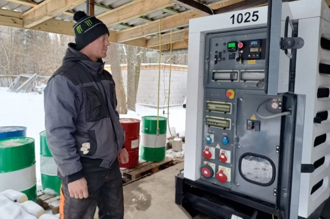 Переселенець Віталій Плис показує генератор, який нещодавно встановили у таборі. Суспільне Луцьк
