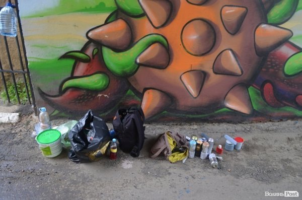 Луцький райтер в центрі міста пише нове графіті. ФОТО