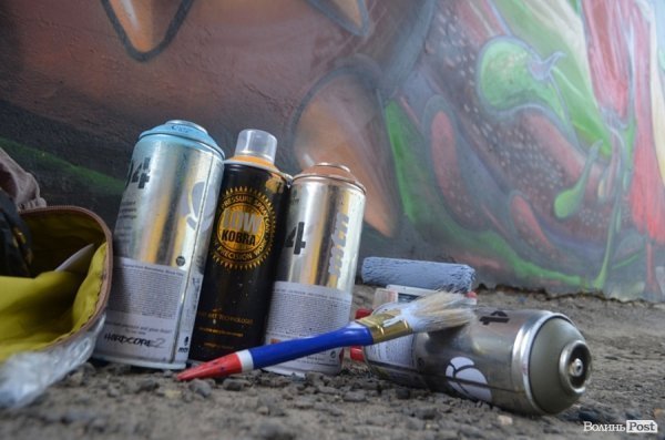 Луцький райтер в центрі міста пише нове графіті. ФОТО