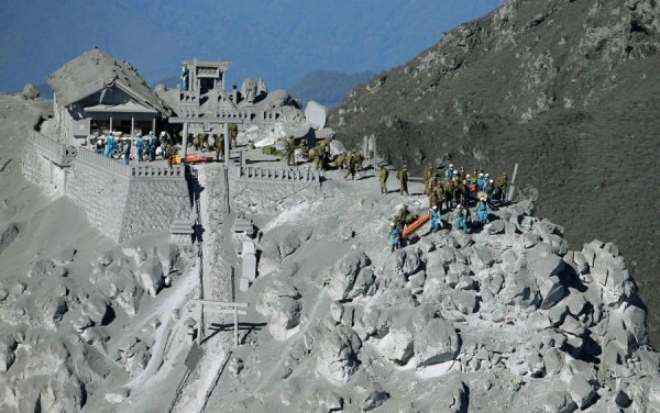 Японські солдати і пожежники шукають людей після виверження вулкана Онтаке. В момент виверження на схилах знаходилися близько 250 осіб, з яких понад 45 загинули. (© Reuters / Kyodo)