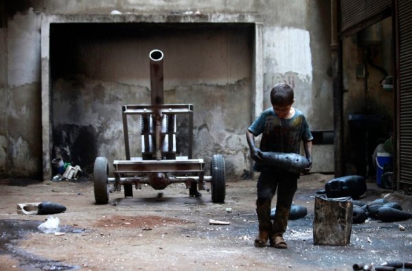 Ісса, 10 років, несе мінометний снаряд на збройовій фабриці Вільної сирійської армії в Алеппо, 7 вересня 2013. HAMID KHATIB, Сирія