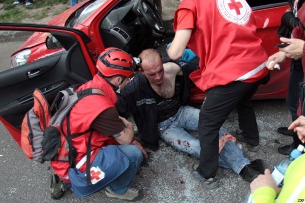 Медики допомагають пораненому у сутичці футбольних фанів із проросійськими радикалами, яка сталась після матчу «Металіст» - «Дніпро» у Харкові, 27 квітня 2014 року