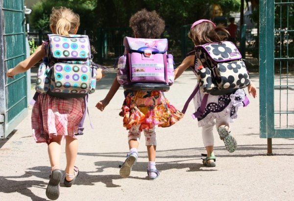 Три школярки поспішають до школи. Німецькі школи першими в Європі закриються на літні канікули (Берлін, Німеччина)