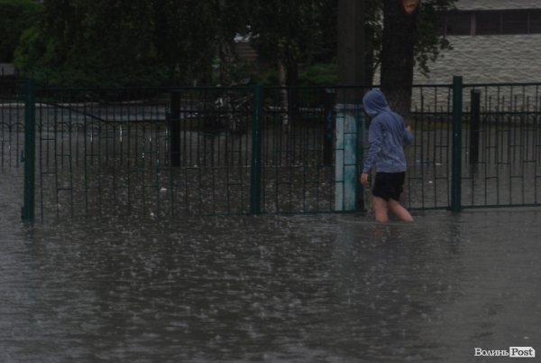 Хлопець міряє калюжу