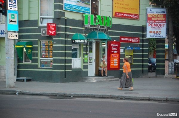 Біля магазину, який працює цілодобово, прохолоджується працівник 