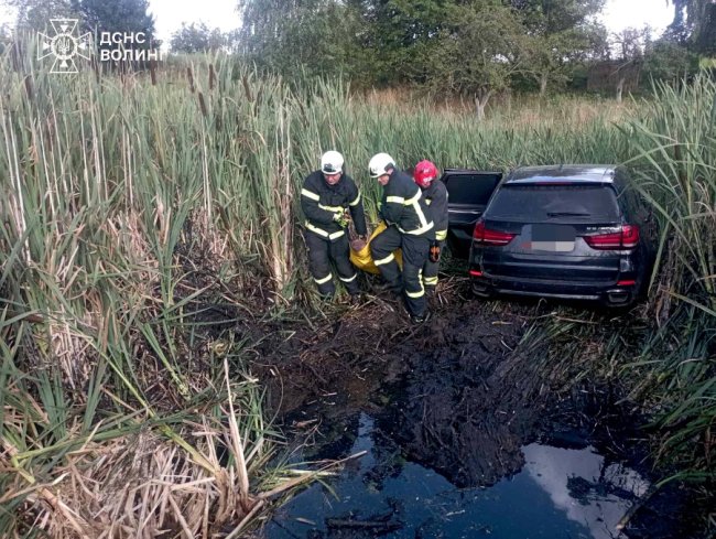 У селі біля Луцька авто з'їхало з дороги у болото, водія діставали рятувальники. ФОТО