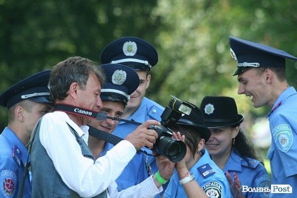 Фотограф Петро Кривошей показує міліції їх світлини