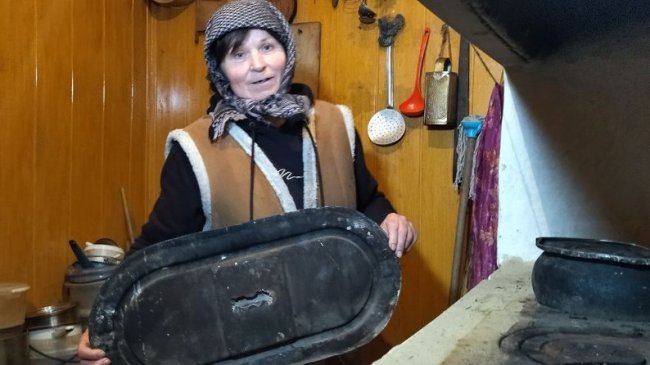 Жителька села Верхи Марія Оліщук показує старий посуд з алюмінію, який зберігся у хаті.