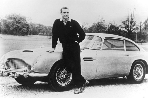 Шон Коннері в ролі Джеймса Бонда позує з Aston Martin DB5, 1965