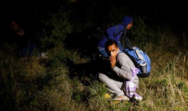 Мігранти, які прибули, за їх словами з Сирії, сидять на землі після затримання сербською поліцією після незаконного переходу кордону з Македонією, 17 липня 2013. MARKO DJURICA, Сербія