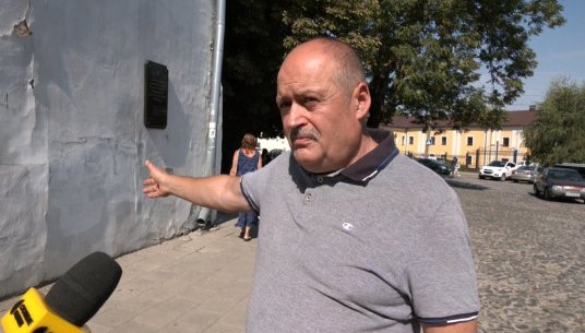 Геннадій Кожевніков показує стіну на Замковій площі у Луцьку, біля якої 23 липня 1989 року відбувся перший мітинг. Суспільне Луцьк