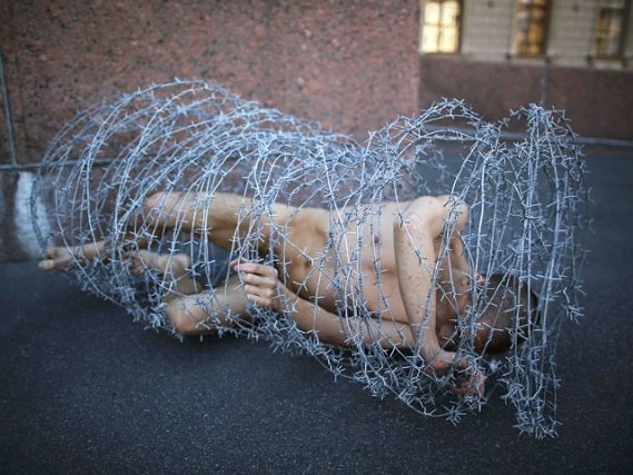 Голий в колючому дроті: у Росії скандальний художник влаштував акцію протесту. ФОТО