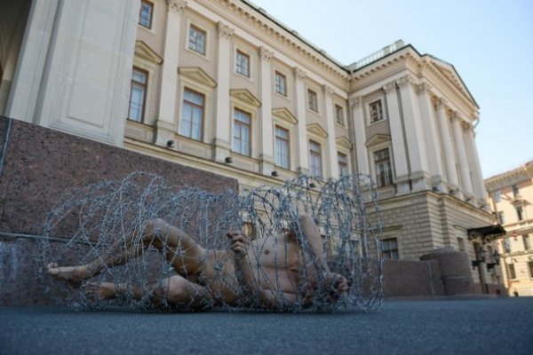 Голий в колючому дроті: у Росії скандальний художник влаштував акцію протесту. ФОТО