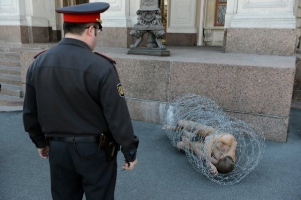 Голий в колючому дроті: у Росії скандальний художник влаштував акцію протесту. ФОТО