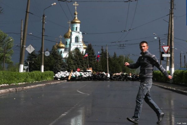 Молодий чоловік перебігає вулицю перед КПП проросійських бойовиків у центрі Слов'янська, 5 травня 2014 року