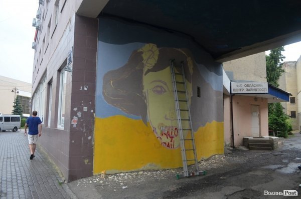 Луцький райтер в центрі міста пише нове графіті. ФОТО