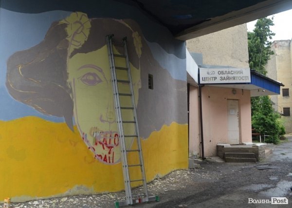 Луцький райтер в центрі міста пише нове графіті. ФОТО