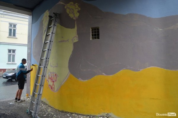 Луцький райтер в центрі міста пише нове графіті. ФОТО