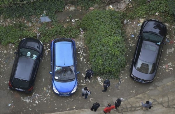 Поліція і свідки навколо покритого рослинністю автомобіля, який був залишений на стоянці більше року тому, в Ченду, провінція Сичуань, Китай 