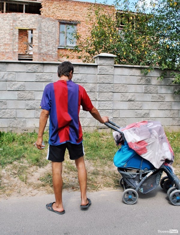 Місцевий мешканець тримає в лівій руці пляшку горілки 