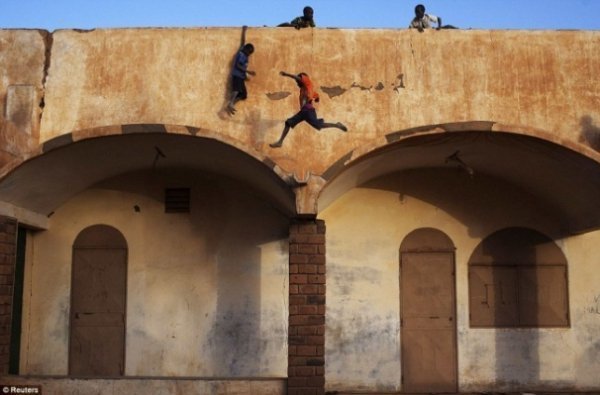 Діти грають на даху біля входу на стадіон в Гао 