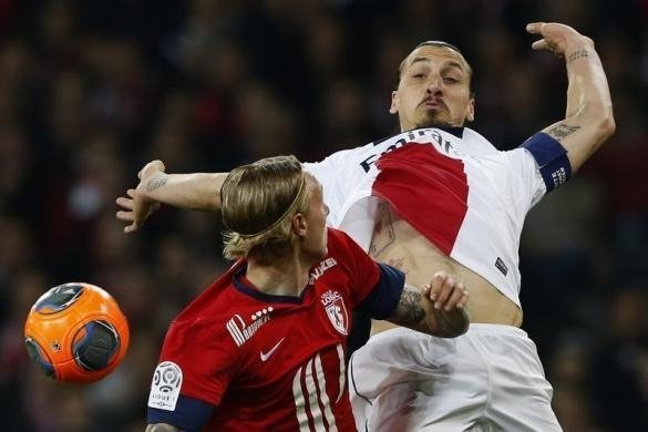 Златан Ібрагімович бореться за м'яч з Лілля Симон Кьяєр під час французької Ліги  