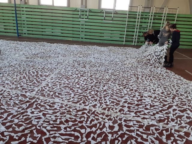 Школярі та вчителі волинської школи сплели величезну маскувальну сітку для воїнів