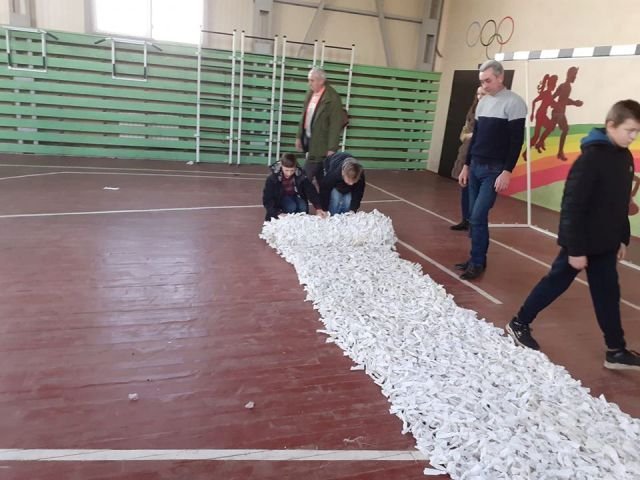 Школярі та вчителі волинської школи сплели величезну маскувальну сітку для воїнів