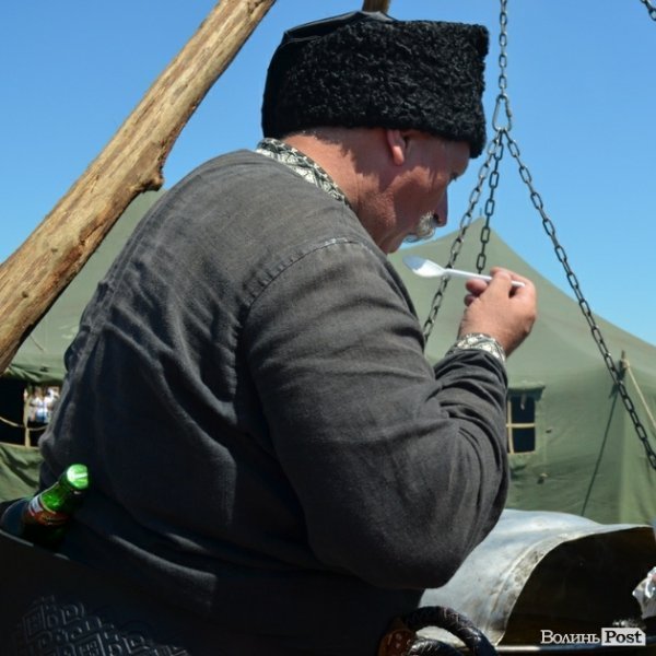 Старшина куштує куліш, за пазухою - пляшка пива для кухаря